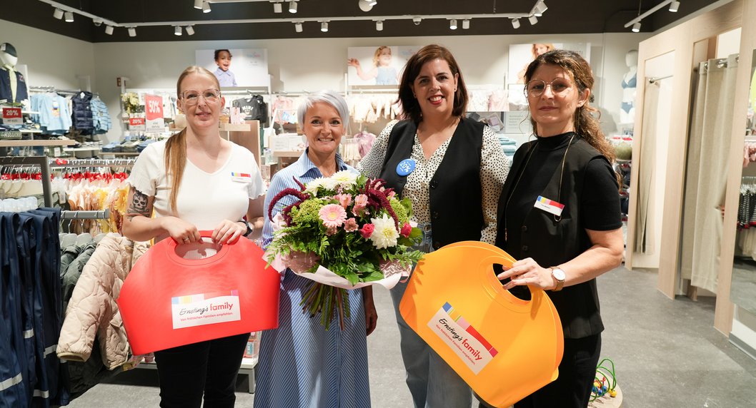 Sabine Riederer mit Blumenstrauß in der Hand und 3 Mitarbeiterinnen von Ernsting's family bei Neueröffnung des Shopsr