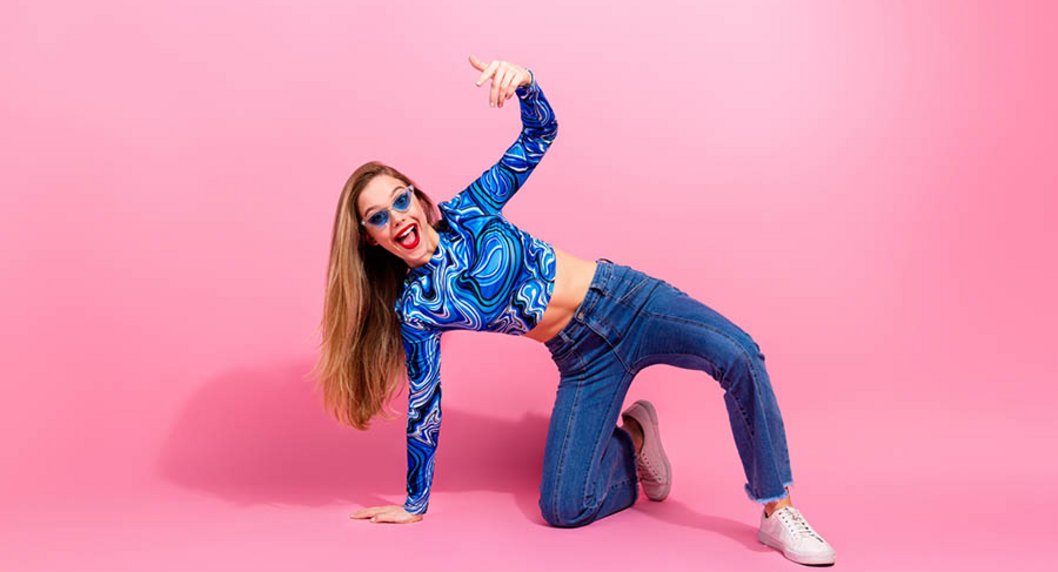 Frau stützt sich mit einem Knie und Hand am Boden auf - in poppigem Blau gekleidet