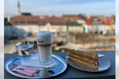 Kaffee und Kuchen auf einem Tisch mit Blick über Tulln