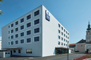 Modernes Best Western Hotel in grau vor einem blauen Himmel