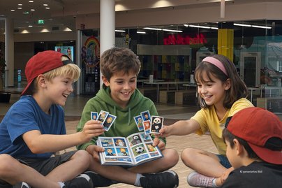KI generiertes Bild mit 4 Kinder im 2OG der Rosenarcade und Tauschen Sticker von einem Album