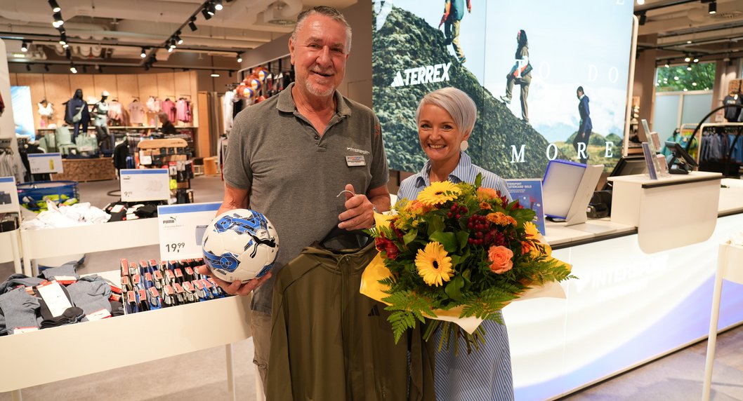 Sabine Riederer mit Filialleiter und Blumenstrauß bei Neueröffnung Intersport Winninger